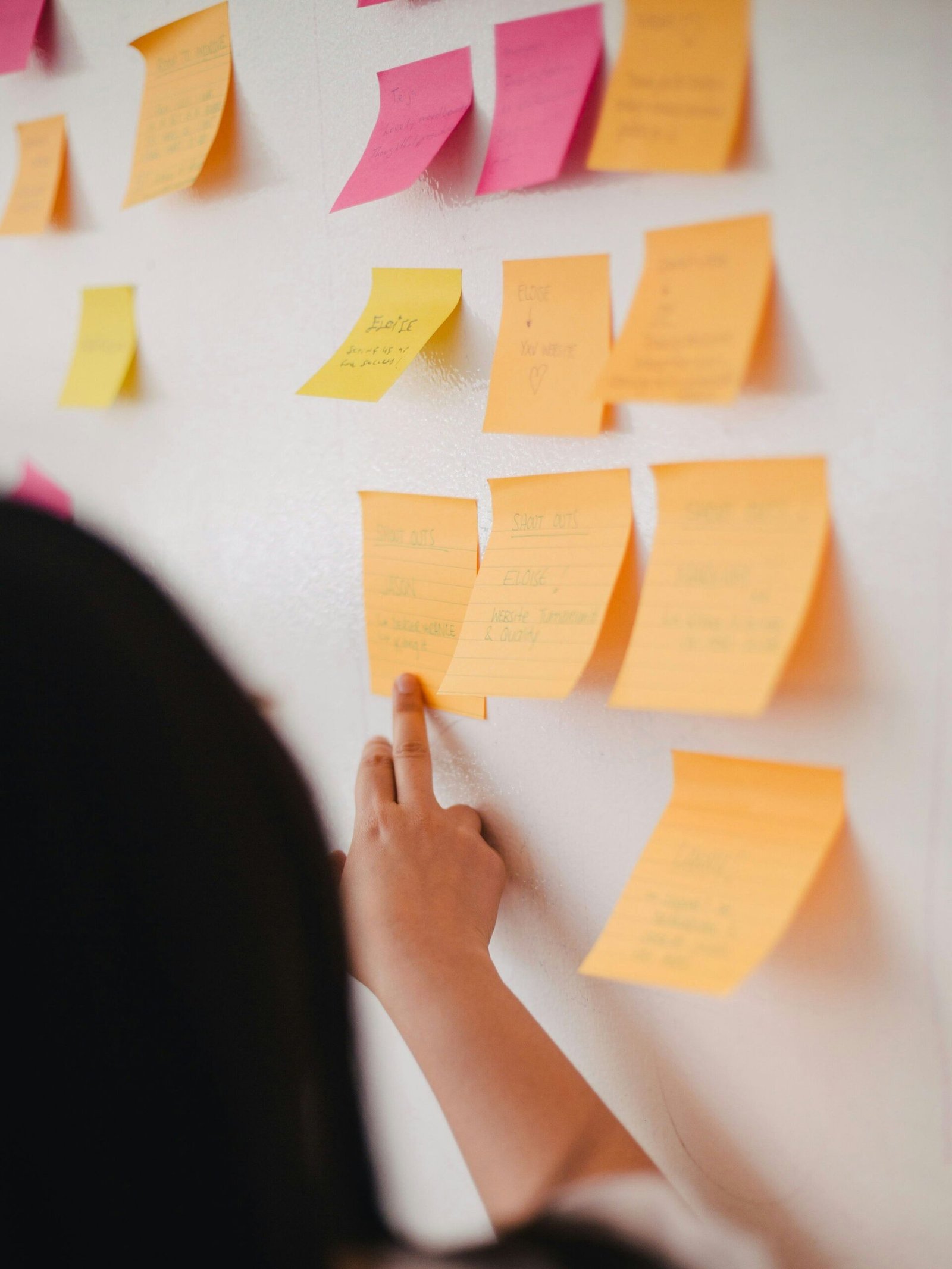 Imagem de mulher apontado para post-its.