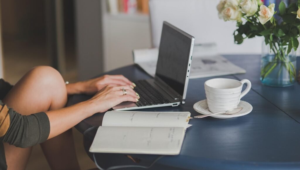 Mulher utilizando computador na mesa.