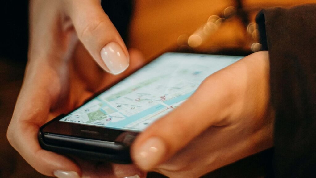 Mãos segurando celular utilizando o Google Mapas